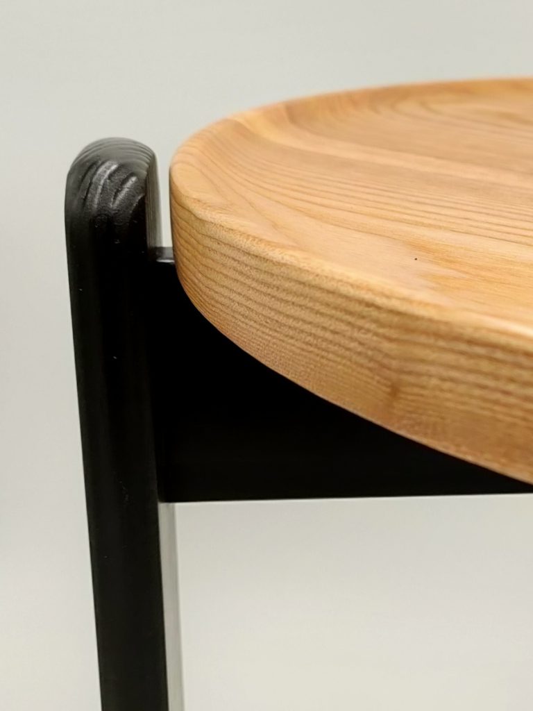 A close up showing the leg and round top detail of the Larix side table.